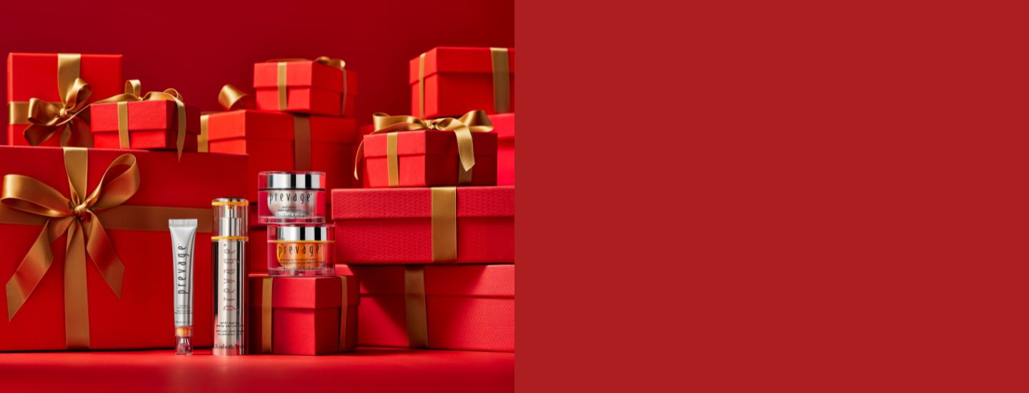 Red gift boxes with gold ribbons and skincare products on a red background