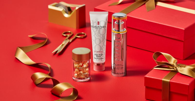 Cosmetic products and gift boxes on a red background